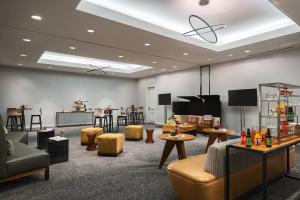 a waiting room with tables and chairs and a waiting area at Renaissance Dallas Addison in Addison