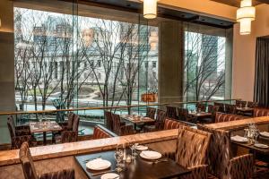 a restaurant with tables and chairs and a large window at The Plaza Hotel Columbus at Capitol Square in Columbus