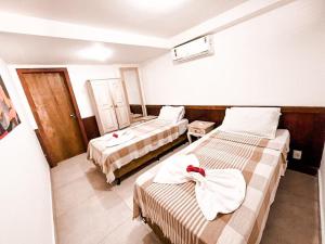 una camera d'albergo con due letti e asciugamani di Privilege Apart Centro Pipa, La Piazzetta by PipaCharme a Pipa