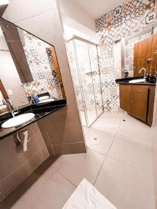 uma casa de banho com um lavatório e um chuveiro em Privilege Apart Centro Pipa, La Piazzetta by PipaCharme em Pipa