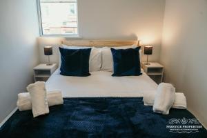 a bedroom with a large bed with blue pillows at Dover St by Prestige Properties SA in Barrow in Furness