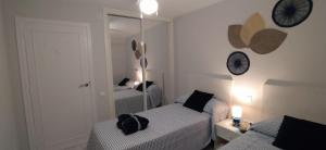 - une petite chambre avec 2 lits et un miroir dans l'établissement LA OCA BENIDORM INFINITY, à Benidorm