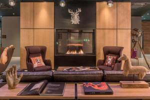 a living room with a couch and a fire place at Moxy Munich Messe in Aschheim