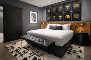 a bedroom with a large bed and a bench at The Union Club Hotel at Purdue University, Autograph Collection in West Lafayette