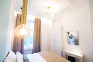 塞拉耶佛的住宿－Luxury Suite in City Centre，一间卧室设有一张床、一个窗户和一个吊灯。