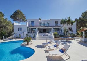 a villa with a swimming pool and chairs at Villa La Residence Ibiza in Sant Josep de sa Talaia