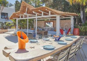 a wooden table with plates and glasses on a patio at Villa La Residence Ibiza in Sant Josep de sa Talaia