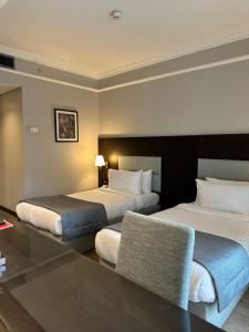 Ramada by Wyndham Downtown Beirut في بيروت: غرفة فندقية بسريرين وطاولة