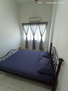 a bedroom with a blue bed with a window at Homestay Nilai D'Jati in Nilai