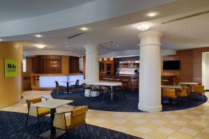 a lobby with tables and chairs and a bar at Courtyard by Marriott Springfield Downtown in Springfield