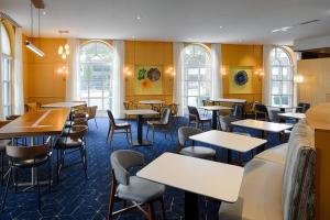 a restaurant with tables and chairs and windows at Courtyard by Marriott Springfield Downtown in Springfield