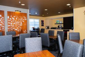 a dining room with tables and chairs and a kitchen at TownePlace Suites Denver Southwest/Littleton in Littleton