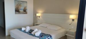 a hotel room with a bed with two pillows at Hôtel Beau Site in Le Lavandou
