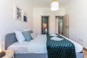 Un dormitorio con una cama grande y un sofá. en Vita Portucale ! Almada Balcony, en Almada