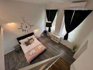 um pequeno quarto com uma cama e uma janela em Absolutum Apartments em Ljubljana