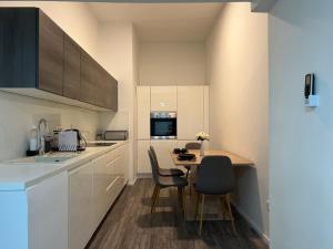 a kitchen with white cabinets and a table and chairs at Absolutum Apartments in Ljubljana