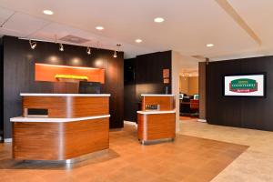 a restaurant with a counter and a television on a wall at Courtyard by Marriott Dallas Northwest in Dallas