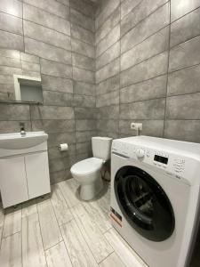 a bathroom with a washing machine and a toilet at GIL Apartments, Volodimirskaja 90.212 - Majetok Bozdosh in Uzhhorod