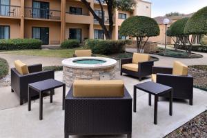 a patio with chairs and tables and a fire pit at Courtyard by Marriott Dallas Northwest in Dallas