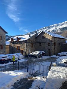 Una persona parada en un estacionamiento con autos cubiertos de nieve. en Casa Margarita, en Sesué