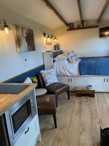 um quarto com uma cama, um sofá e uma mesa em Silver Fern Glamping em Aberystwyth