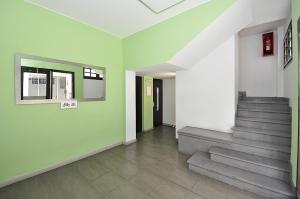 un couloir avec des escaliers et un mur vert dans l'établissement Apartamento Holanda, à Lloret de Mar