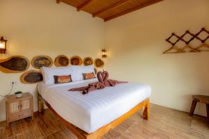 a bedroom with a bed with wooden logs on the wall at Khao Sok River Home Resort in Khao Sok