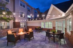 un patio esterno con tavoli, sedie e luci di Residence Inn by Marriott State College a State College