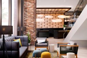 a lobby with couches and chairs and a staircase at Delta Hotels by Marriott Calgary Downtown in Calgary