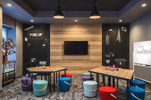 a restaurant with two tables and chairs and a tv at MOXY Tokyo Kinshicho in Tokyo