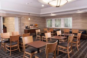 une salle à manger avec des tables et des chaises en bois dans l'établissement TownePlace Suites The Villages, à The Villages