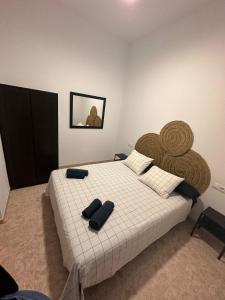 a bedroom with a large bed with two pillows on it at La casa de la Abuela in Málaga