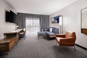 a hotel room with a couch and a desk at Courtyard Mobile in Mobile