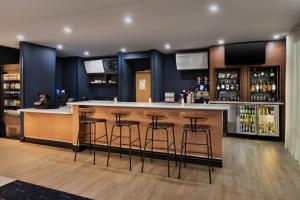 a bar in a restaurant with stools at Courtyard Mobile in Mobile