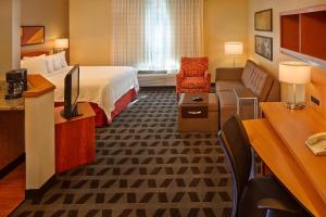 a hotel room with a bed and a couch at TownePlace Suites by Marriott Orlando East/UCF Area in Orlando