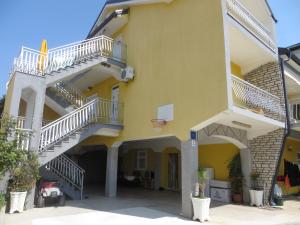 帕科坦Apartments Tonka的黄色的建筑,有楼梯和篮球架