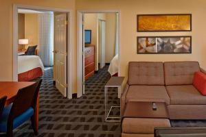 um quarto de hotel com um sofá e uma cama em TownePlace Suites by Marriott Orlando East/UCF Area em Orlando