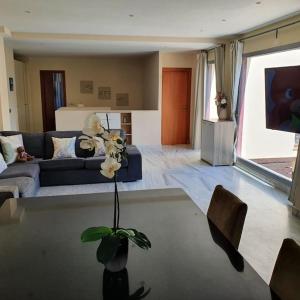 een woonkamer met een bank en een bloem in een vaas bij Exclusive Villa in Benahavis in Estepona