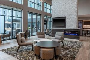a lobby with a fireplace and tables and chairs at Residence Inn by Marriott Lancaster Palmdale in Lancaster