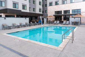 a swimming pool at a hotel with tables and chairs at Residence Inn by Marriott Lancaster Palmdale in Lancaster