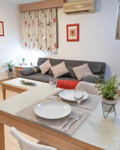 a living room with a table with plates and wine glasses at Oasis Playa Maspalomas in Maspalomas