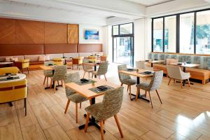 a dining room with tables and chairs and windows at San Diego Marriott Mission Valley in San Diego