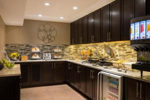 a large kitchen with black cabinets and a refrigerator at Fairfield Inn by Marriott Boston Sudbury in Sudbury