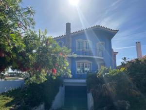 uma casa azul com o sol brilhando nela em NO CEU - A fully private flat in the sky with Ocean view em Atouguia da Baleia