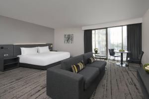 a hotel room with a bed and a couch at Courtyard by Marriott Brisbane South Bank in Brisbane