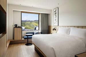 a hotel room with a bed and a window at Fairfield by Marriott Nara Tenri Yamanobenomichi in Tenri