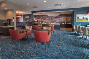 a lobby of a hotel with red chairs and a bar at Fairfield Inn & Suites by Marriott Altoona in Altoona