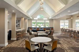 une salle d'attente avec des tables et des chaises ainsi qu'un bar dans l'établissement Residence Inn By Marriott Vacaville, à Vacaville