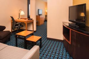 Habitación de hotel con sofá, TV y escritorio. en Fairfield Inn and Suites by Marriott San Antonio Northeast / Schertz / RAFB en Schertz