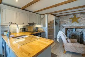 a kitchen with a sink and a counter top at Stunning Riverside Fisherman's Cottage in Stoke Gabriel